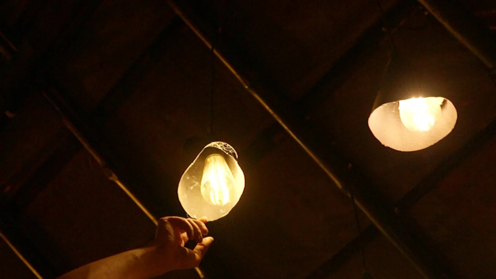 Looking up at the handmade Edison bulb lamps hanging from the bamboo ceiling grid of the café
